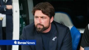 Rangers manager Russell Martin looks frustrated while sat in the dugout.