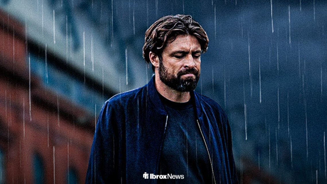 Russell Martin looks down outside of Ibrox in the rain.