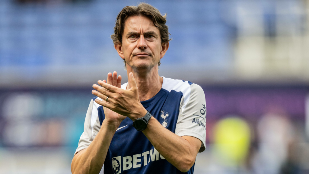 Tottenham manager Thomas Frank stands and applauds the fans after a game.