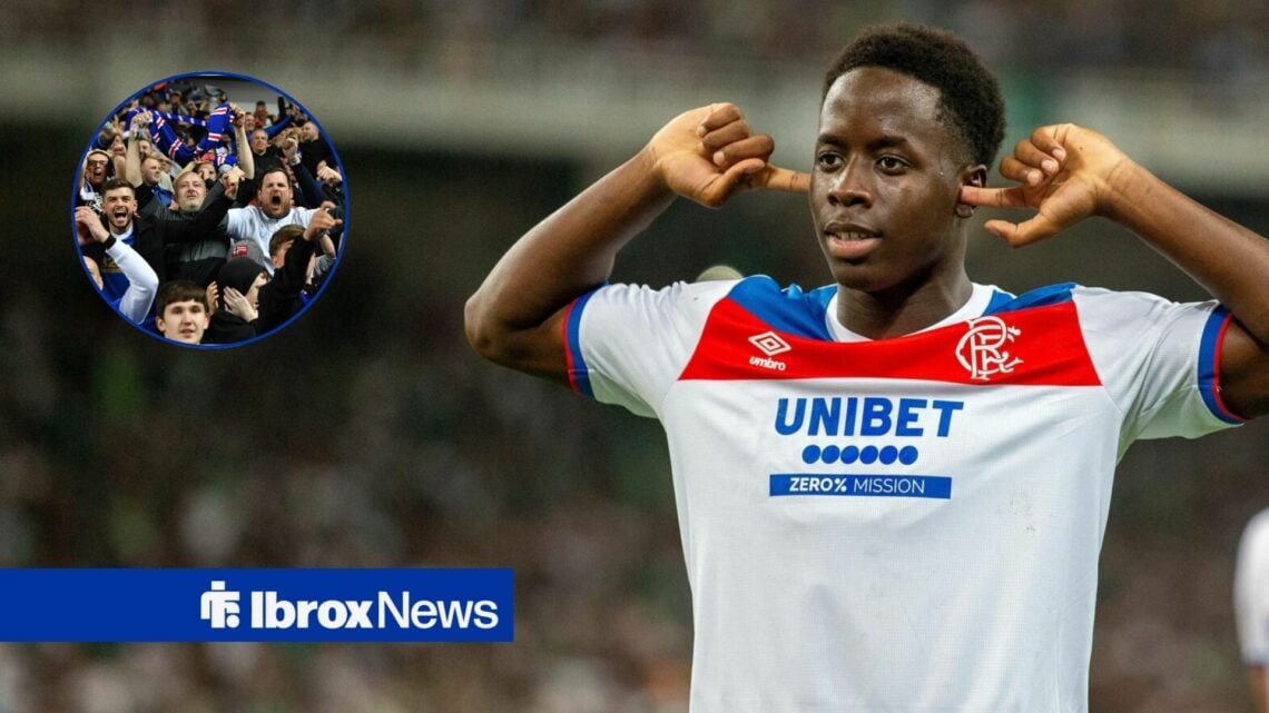 Djeidi Gassama points at his ears whilst stood alongside a circle inset of Rangers fans.