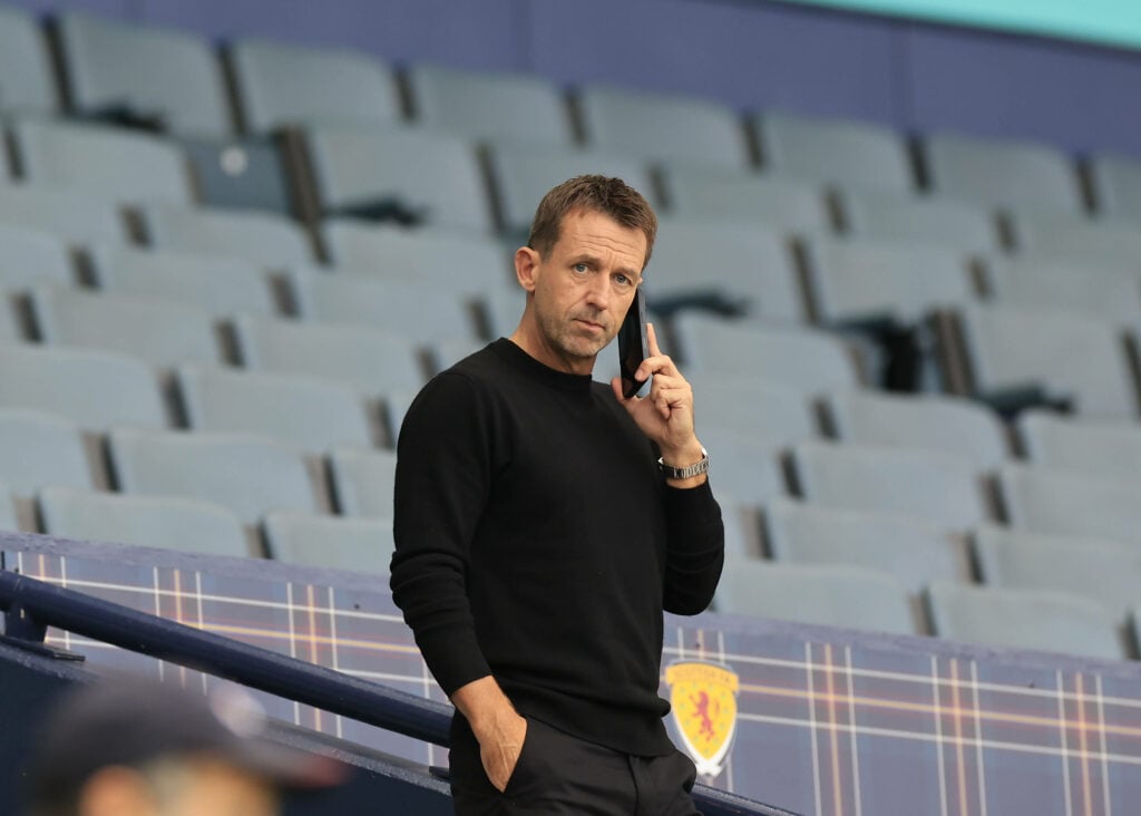 Neil McCann is spotted on his phone at Hampden Park.