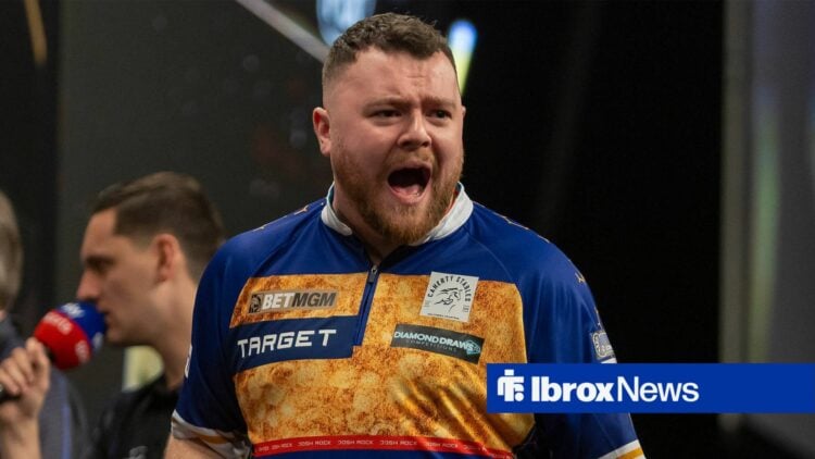 Josh Rock celebrating a win on stage at the darts