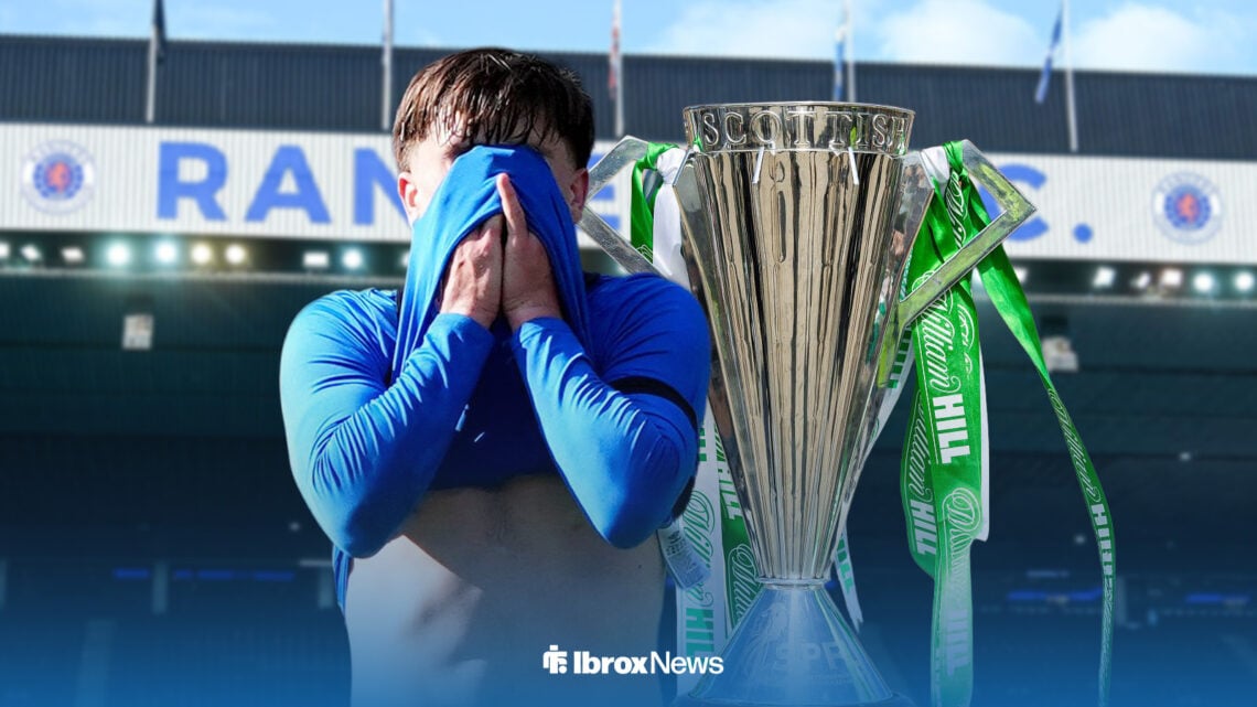 Mikey Moore has his head in his hands, with the Scottish Premiership trophy behind him